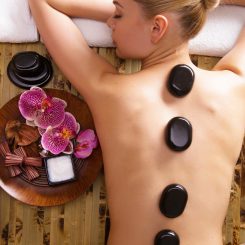 Beautiful woman relaxing in spa salon with hot stones on body. Beauty treatment therapy